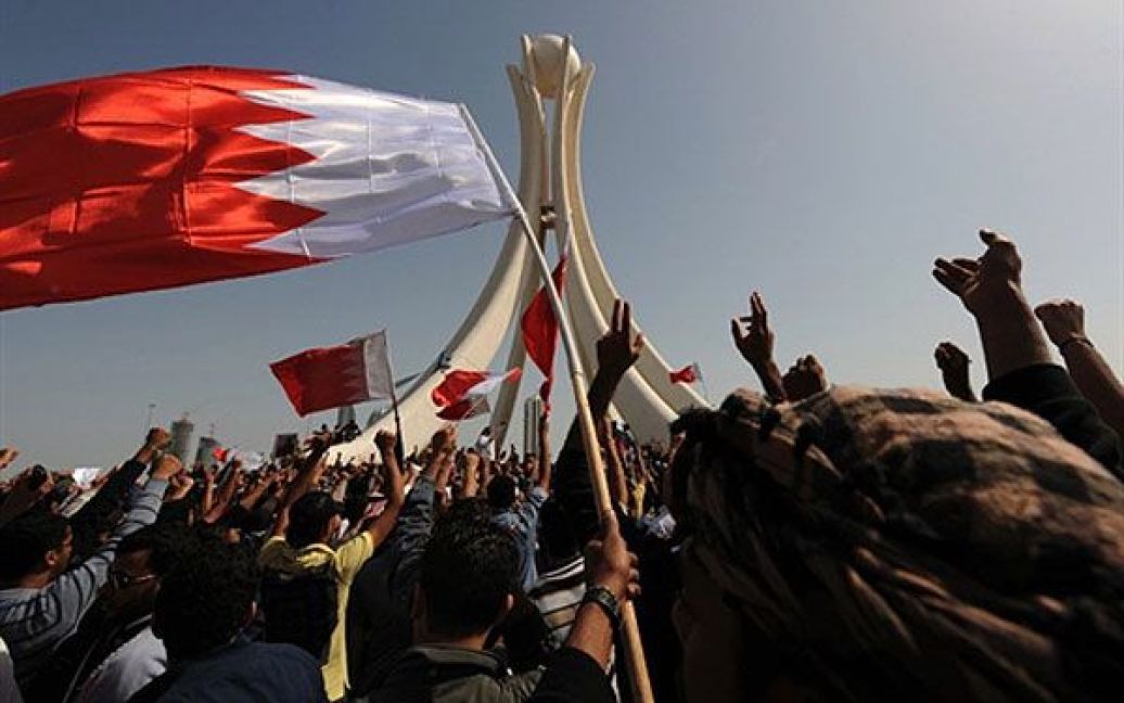 Бахрейн, Манама. Бахрейнські, здебільшого шиїтські, учасники акції протесту розмахують своїм національним прапором і скандують гасла під час демонстрації на площі Перл у Манамі. Шиїтська опозиція закликала вжити заходів для створення реальної конституційної монархії у Бахрейні на чолі з обраним прем&#039;єр-міністром. / © AFP