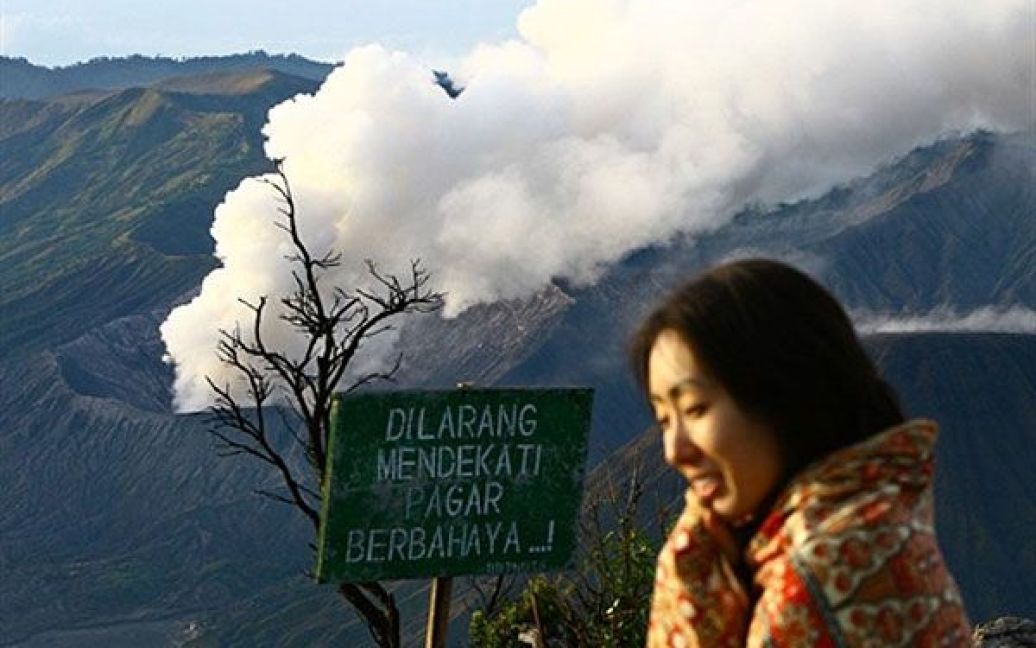 Індонезія, Пасуруан. Туристка на тлі вулкана Бромо, який почав викидати дим з кратеру у провінції Східна Ява. У Індонезії оголошено "червоний рівень" небезпеки через виверження вулкана Бромо, яке сталось менш ніж через місяць після виверження вулкана Мерапі. / © AFP