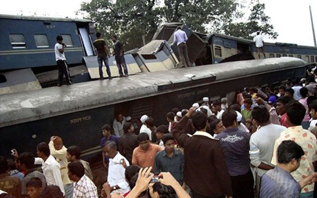 Бангладеш, Наршингді. Рятувальники і перехожі пробираються крізь уламки поїздів, які зіткнулися у 30 км від столиці Бангладеш Дакки. Жертвами зіткнення двох пасажирських поїздів у Бангладеш стали щонайменше 19 людей, близько 300 отримали поранення. / © AFP