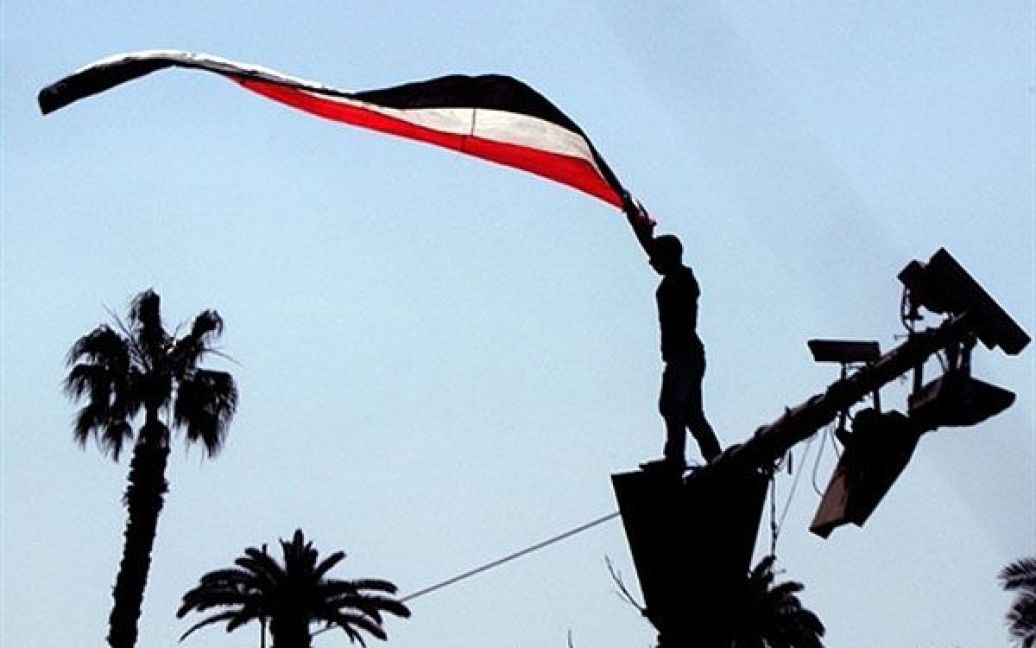 Єгипет, Каїр. Єгипетянин тримає національний прапор перед п&#039;ятничною молитвою, якою відсвяткували закінчення режиму колишнього президента Єгипту Хосні Мубарака і успіх революції у Єгипті. / © AFP