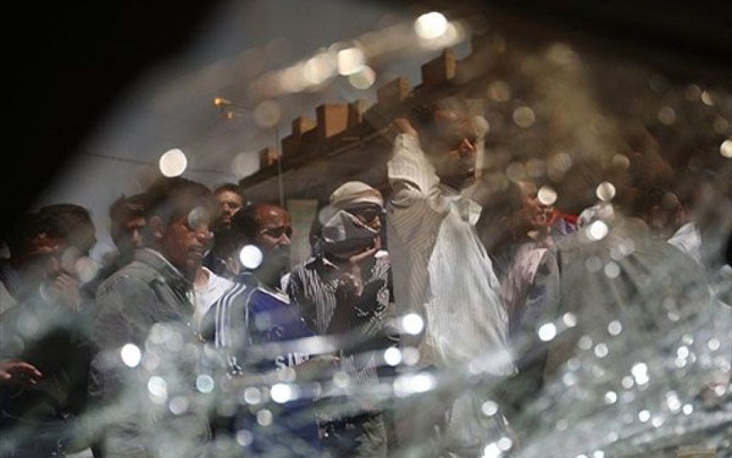 Ємен, Сана. Єменські антиурядові демонстранти стоять поруч із робитим під час акції протесту автомобілем. У Сані тривають багатотисячні протести із закликами до повалення президента країни Алі Абдалли Салеха. / © AFP