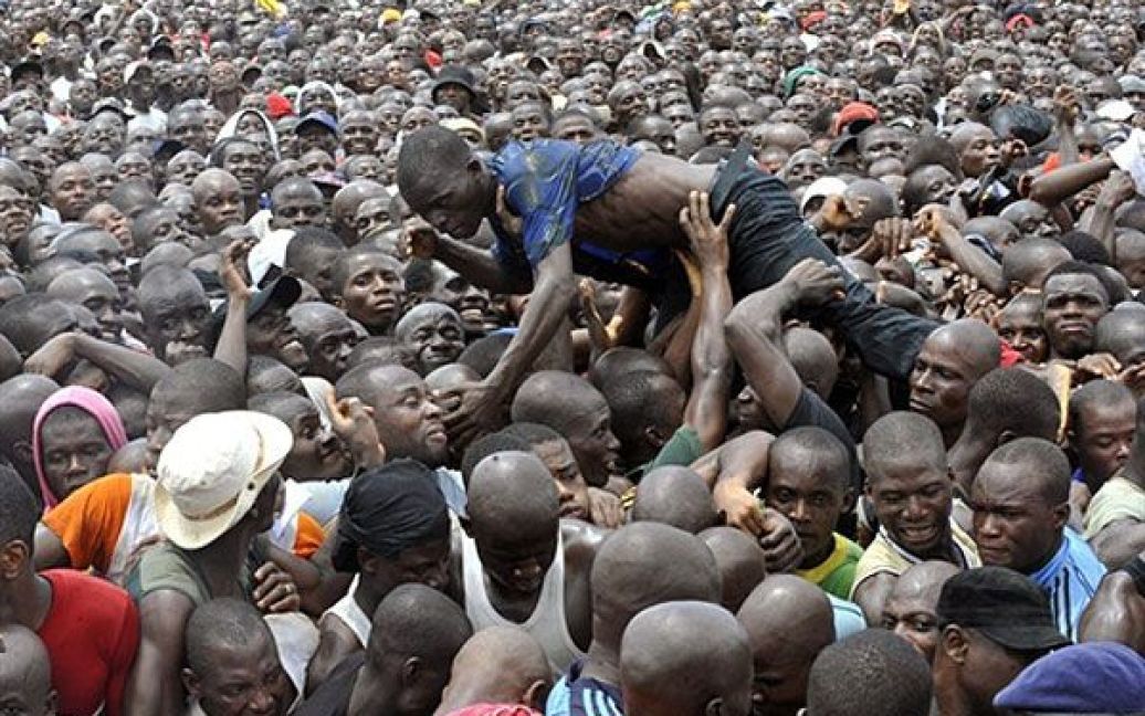 Кот-д&#039;Івуар, Абіджан. Чоловіка несуть на руках під час кількатисячного мітингу прихильників Лорана Гбагбо, які зібралися проходити службу в армії Кот-д&#039;Івуара. / © AFP