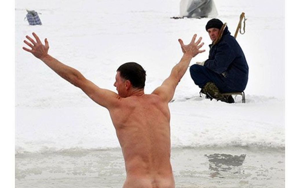 Білорусь, Мінськ. Чоловік пірнає у крижану воду озера Чіжовське у Мінську / © AFP