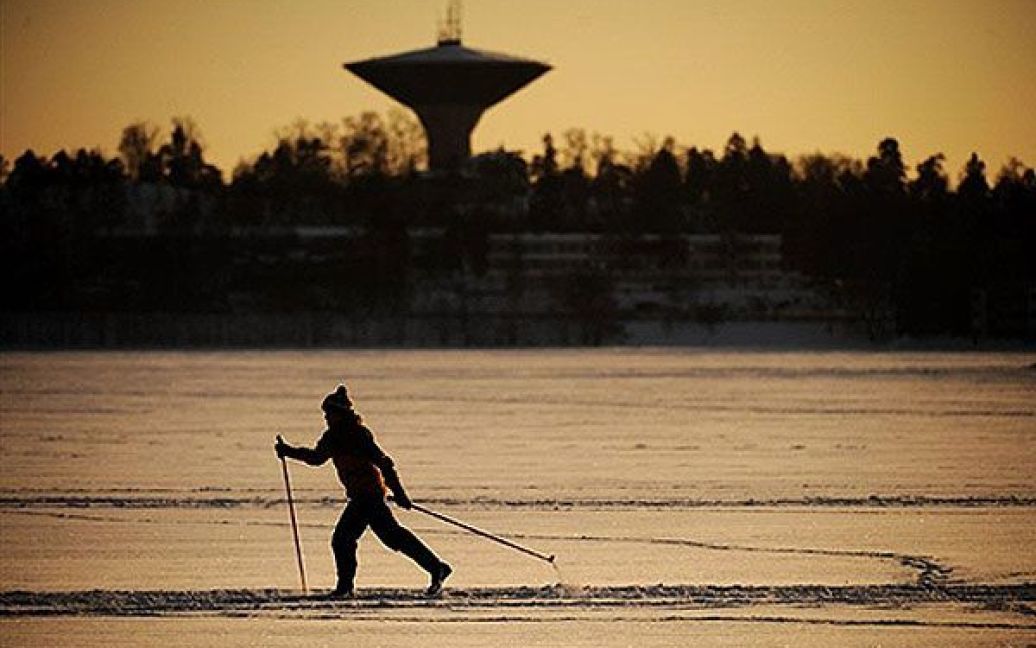 Фінляндія, Гельсінкі. Жінка йде на бігових лижах по льоду озера за межами Гельсінкі. Зимові морози у Фінляндії цього року є рекордними, температура впала до - 37,9 градусів за Цельсієм. / © AFP