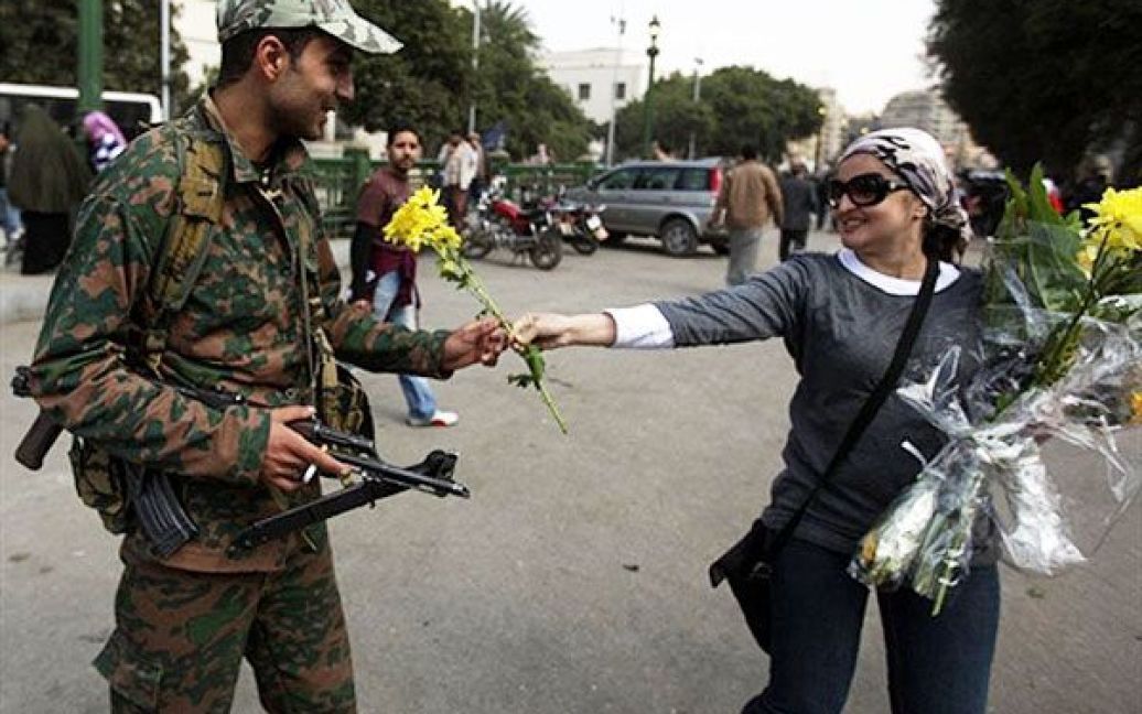 Єгипет, Каїр. Єгипетська жінка пропонує квітку солдату на площі Тахрір у Каїрі. / © AFP