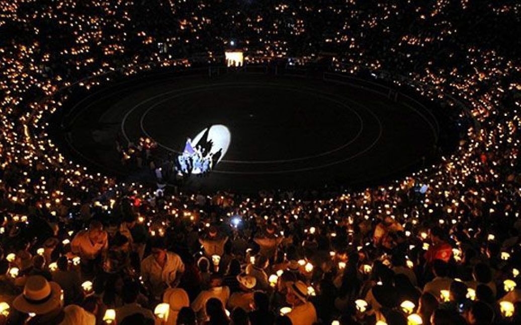 Колумбія. Люди запалюють свічки на честь Діви Макарени перед боєм биків на арені Канавералехо у Калі. / © AFP