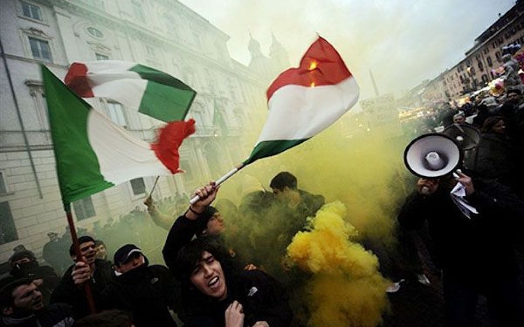 Італія, Рим. Демонстранти розмахують італійським прапором перед посольством Бразилії в Римі. На площі Навона провели акцію протесту проти відмови президента Бразилії екстрагувати екс-військового Чезаре Баттісті. Президент Луїс Інасіо Лула да Сільва 31 грудня відмовився видавати Баттісті, члена радикального лівого руху "Збройний пролетаріат за комунізм", який убив кількох людей у 70-ті рр. в Італії. / © AFP