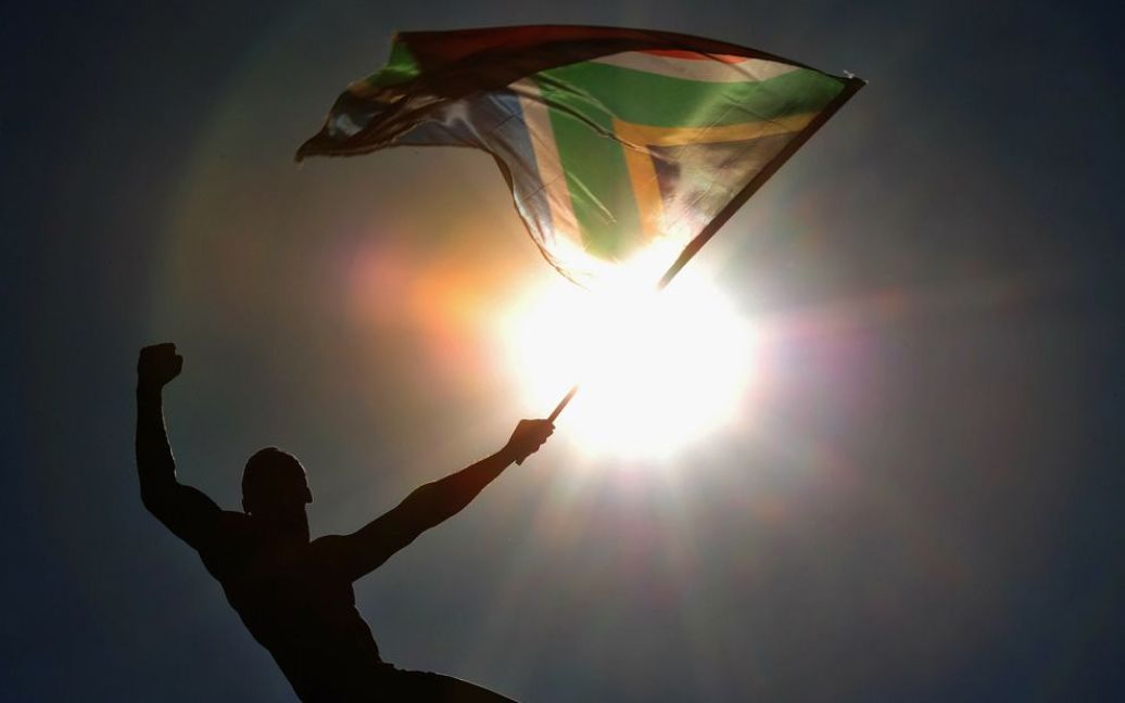 Футбольний уболівальник з прапором ПАР перед Чемпіонатом світу з футболу 2010 у Сендтоні. (Clive Mason / Getty Images) / © The Boston Globe