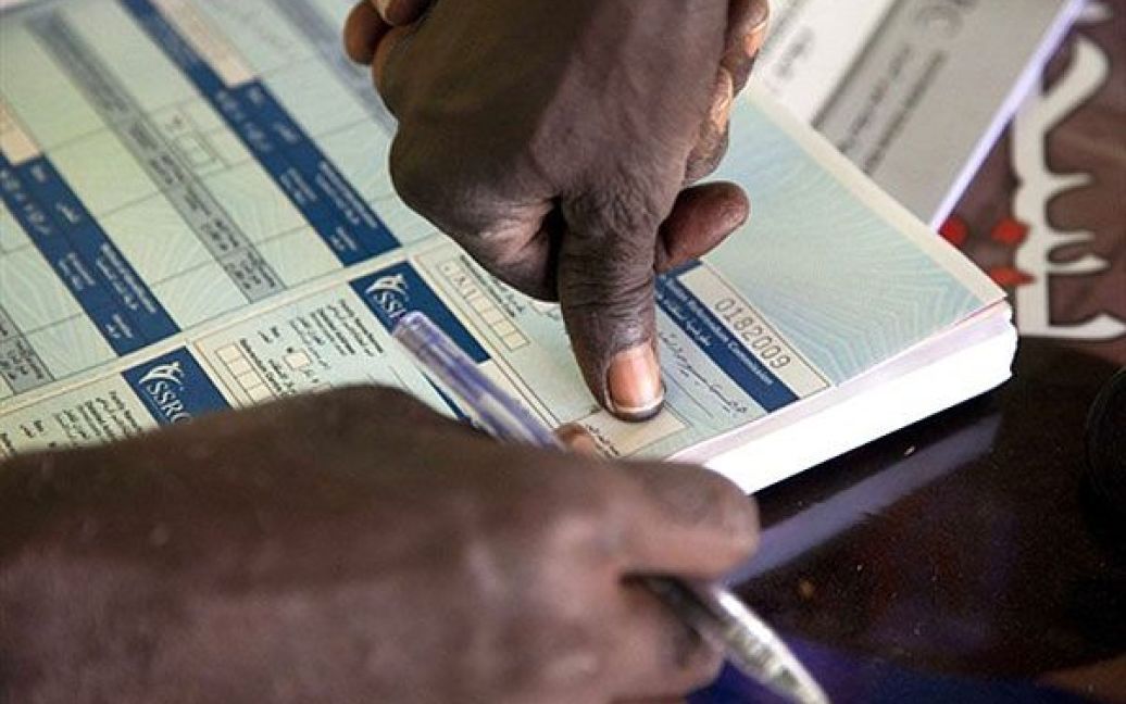 Судан, Аль-Фашер. Суданець залишає відбитки пальців на посвідченні особи, що дає йому право взяти участь у майбутньому референдумі, який відбудеться в Судані 9 січня. На референдум винесене питання про можливість повної незалежності півдня країни. / © AFP