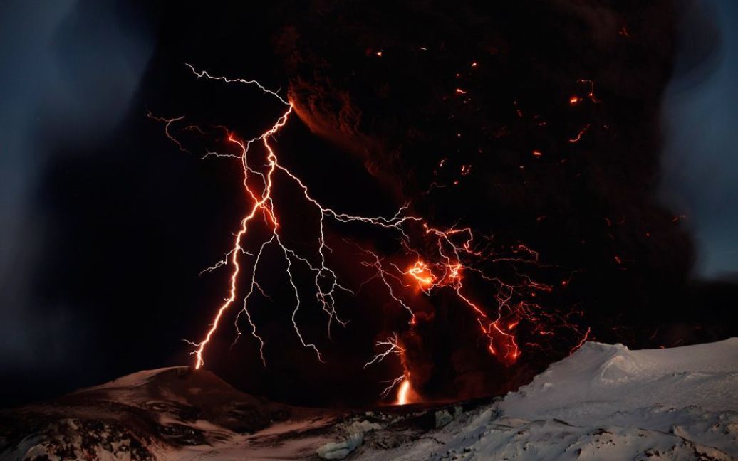 Блискавка на тлі лави під час виверження вулкана Ейяфьятлайокудль в Ісландії. Вулкан протягом кількох тижнів вивергав попіл і дим, викликавши численні затримки авіарейсів по всій Європі. (REUTERS / Lucas Jackson) / © The Boston Globe