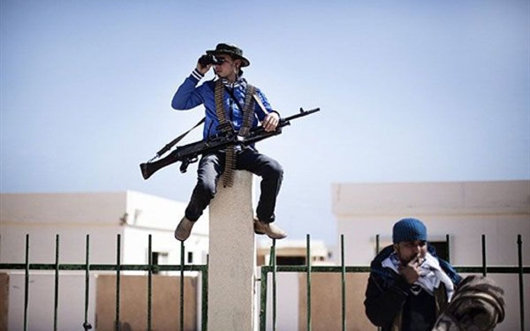Лівійська Арабська Джамахірія, Рас Лануф. Лівійський бойовик-повстанець у бінокль спостерігає за небом над містом Рас Лануф. Лівійські ВПС продовжують атакувати місто, захоплене повстанцями. / © AFP