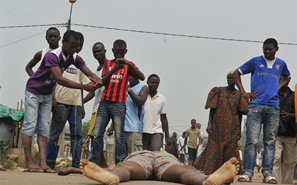 Кот-д&#039;Івуар, Абіджан. Мешканці фотографують тіло людини, вбитої в результаті обстрілу в Абіджані. Принаймні, двоє цивільних осіб були вбиті під час тривалих сутичок. / © AFP