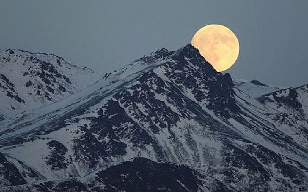 США, штат Аляска. Місяць піднімається над горою Чугач поблизу Ігл-Рівер, штат Аляска. / © AFP