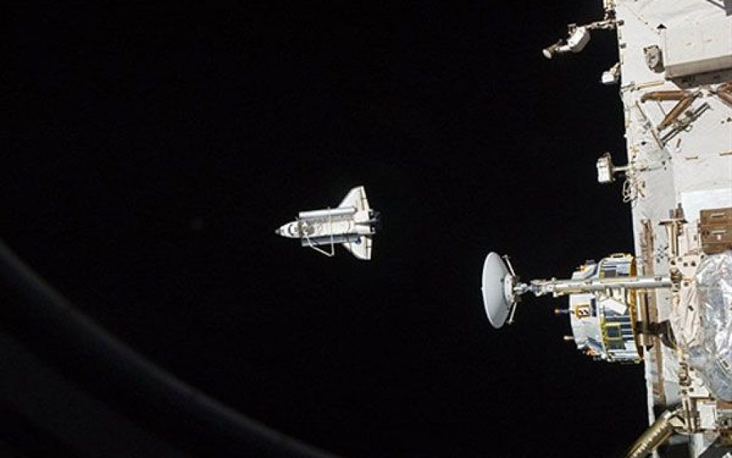 Космічний човник "Діскавері" видно з Міжнародної космічної станції після розстиковки. "Діскавері" виконає свою остаточну посадку на Землю 9 березня після майже ідеального виконання останньої місії на МКС. Фото AFP/NASA. / © AFP
