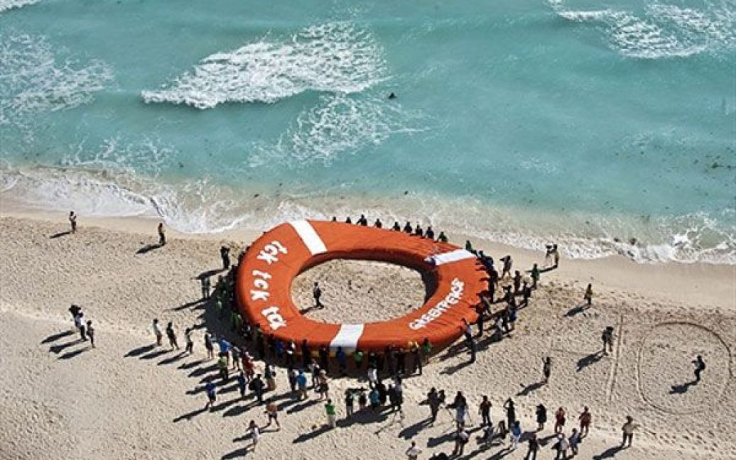 Мексика, Канкун. Активісти руху "Грінпіс" провели акцію у Канкуні із гігантським надувним рятувальним кругом під час проведення рамкової конвенції ООН з питань зміни клімату. / © AFP