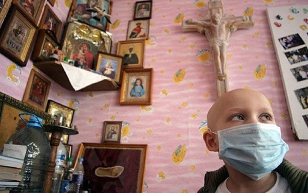 Україна, Донецьк. Дитина у захисній масці, стоїть в кімнаті лікарні для людей, які страждають від лейкемії. Українські діти та дорослі, деякі з яких стали жертвами аварії на Чорнобильській АЕС у 1986 році, проходять у клініці курс лікування. / © AFP