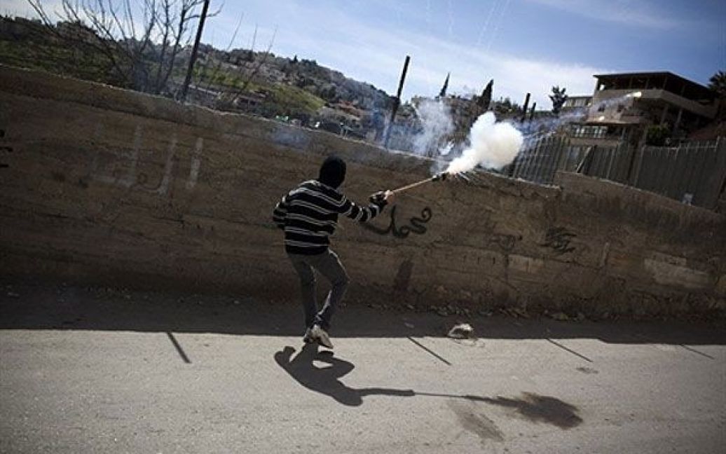 Єрусалим. Палестинський юнаку масці кидає фаєр у напрямку ізраїльських прикордонників під час зіткнень у східному районі Єрусалиму Сильван. / © AFP