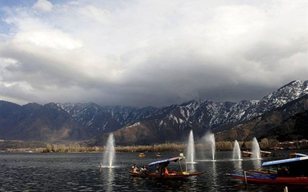 Індія, Срінагар. Кашмірські мусульмани пливуть на своїх традиційних човнах shikara проти вітру під дощем на озері Дав у Срінагарі. Цього року Кашмірська долина зіткнулась з виключно суворою зимою. / © AFP