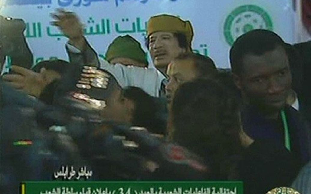 Лівійська Арабська Джамахірія, Тріполі. Лівійський лідер Муаммар Каддафі жестикулює до своїх прихильників на мітингу в Тріполі, де сталися зіткнення між його прибічниками та повстанцями. Фото AFP /LIBYAN TV / © AFP