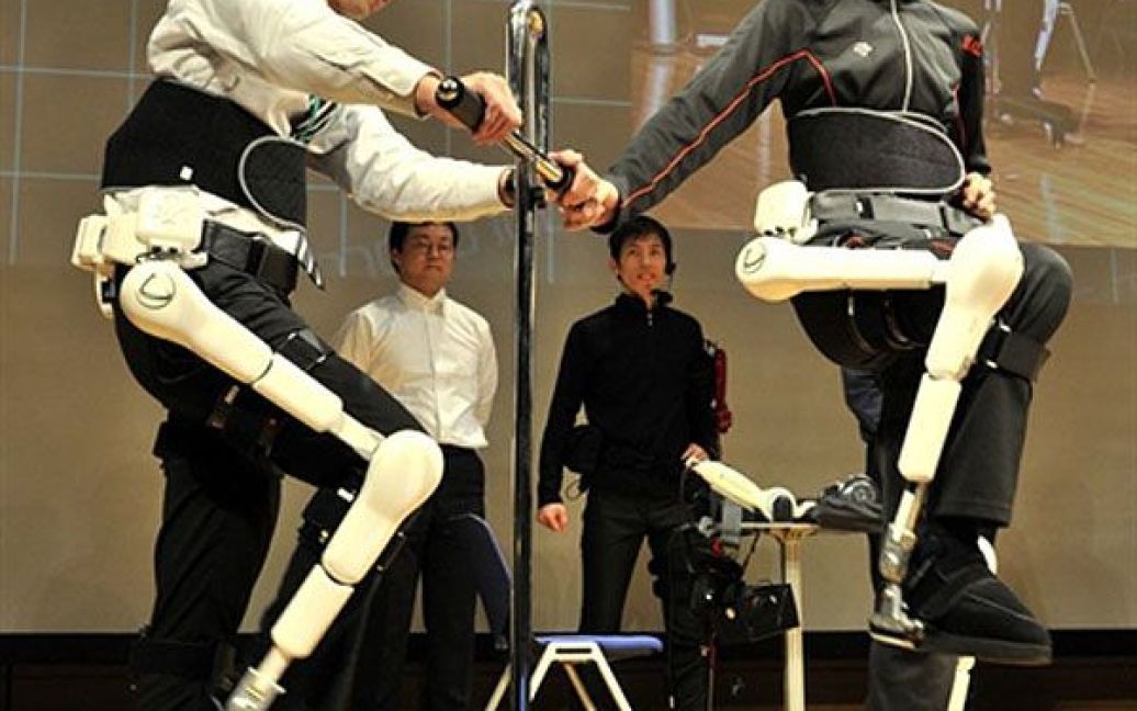 Японія, Токіо. Співробітник компанії Cyberdyne демонструє новий робот-екзоскелет, який синхронізує дії "майстра" та дії "користувача". Екзоскелет використовуватимуть для навчання людей з обмеженими фізичними можливостями. / © AFP