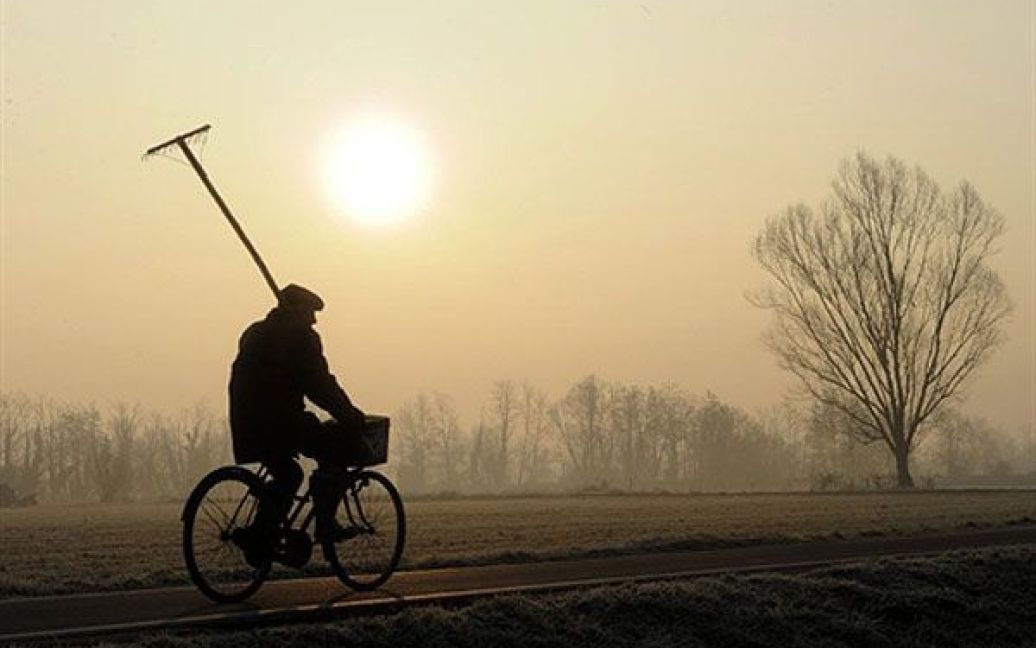 Італія, Аббіатеграссо. Чоловік їде на велосипеді сільською місцевістю Аббіатеграссо, на захід від Мілана. / © AFP