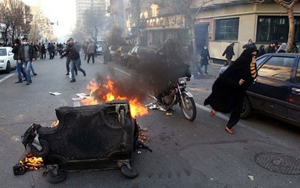 Іран, Тегеран. Іранські протестувальники підпалили cміттєвий контейнер на вулиці під час антиурядової демонстрації, яку провели під приводом підтримки арабського повстання. / © AFP