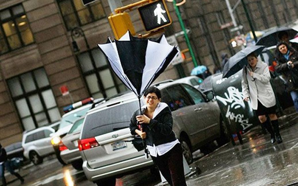 США, Нью-Йорк. Жінка намагається втримати парасольку під час сильного вітру та дощу у Брукліні. Потужний вітер з проливним дощем налетів на Східне узбережжя. / © AFP