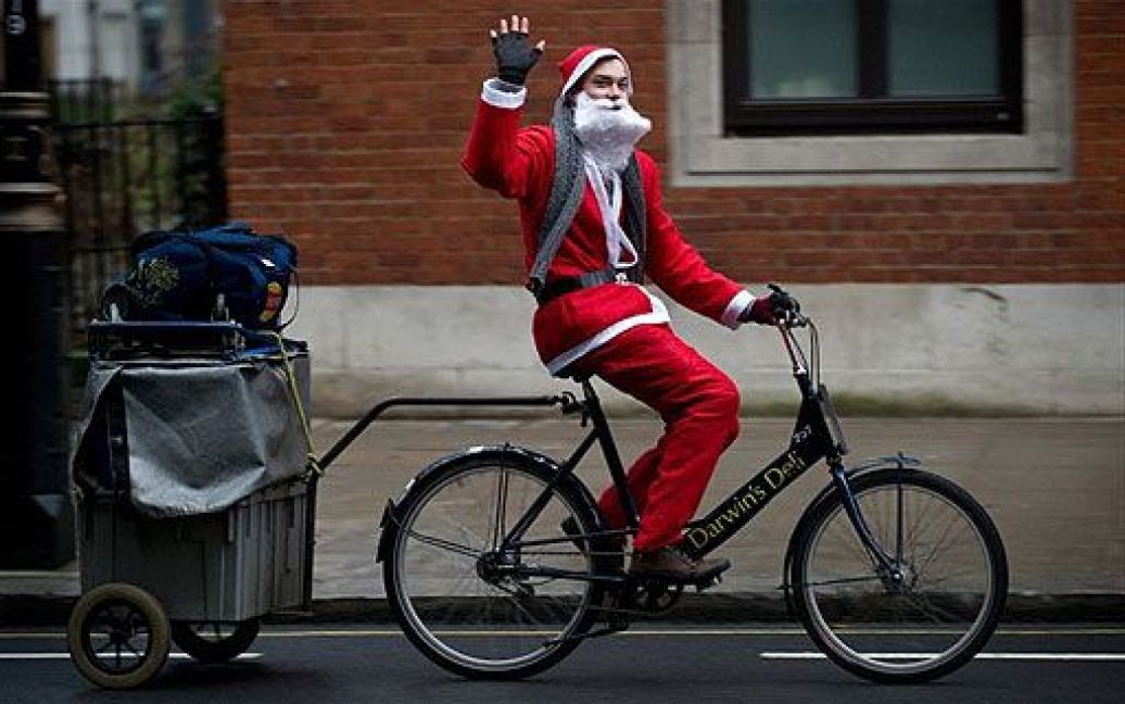Великобританія, Лондон. Кур&#039;єр із доставки сендвічів, одягнений у костюм Діда Мороза, їде на велосипеді центром Лондона. / © AFP