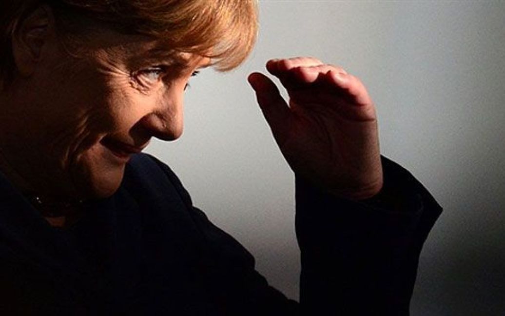 Німеччина, Берлін. Федеральний канцлер Німеччини Ангела Меркель ховається від сонця під час спільної прес-конференції з прем&#039;єр-міністром Італії Сильвіо Берлусконі у Берліні. / © AFP