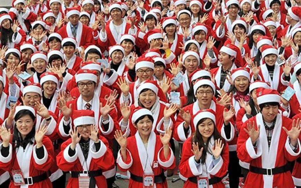 Республіка Корея, Сеул. Південнокорейські волонтери у костюмах Санта-Клаусів зібрались, щоб роздати різдвяні подарунки новонародженим у Сеулі. Волонтери відвідали близько 60 будинків, в яких вигодовують недоношених немовлят. / © AFP