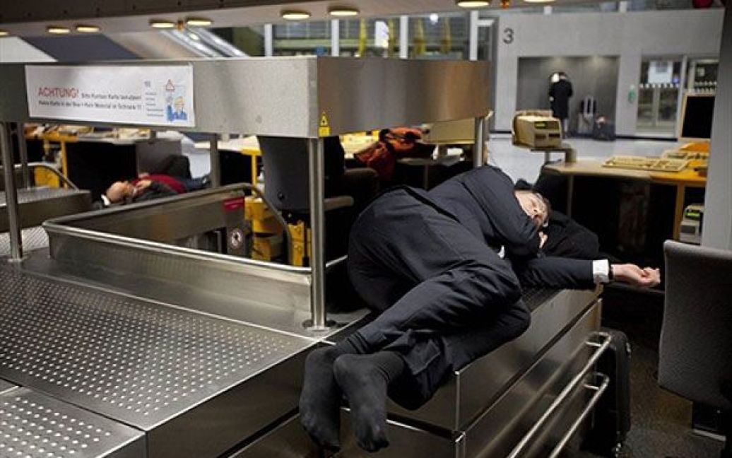 Німеччина, Франкфурт-на-Майні. Пасажири сплять на багажу в міжнародному аеропорту Франкфурта-на-Майні. Через сильний снігопад на чотири години був закритий найбільш завантажений аеропорт Німеччини, було скасовано майже 1400 рейсів. / © AFP