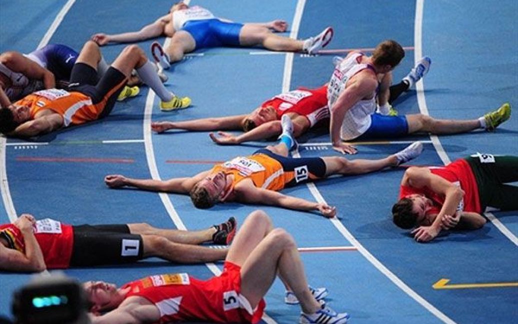 Франція, Париж. Атлети лежать на доріжці після забігу на 1000 м серед чоловіків на Чемпіонаті Європи з легкої атлетики у приміщеннях. / © AFP