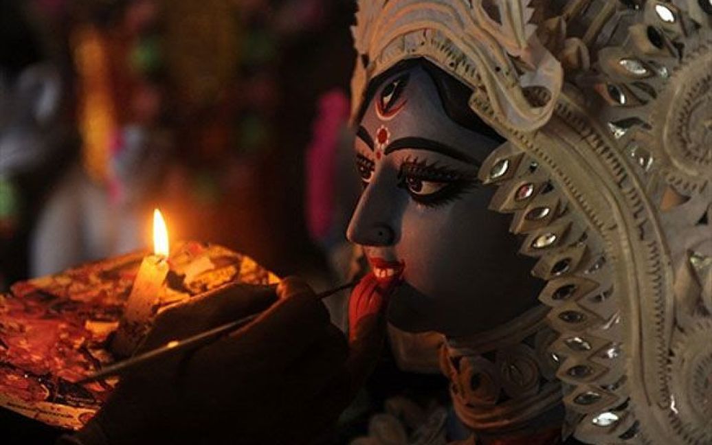 Індія, Сілігурі. Індійський художник завершує роботу над ідолом індуїстської богині Калі напередодні свята Дівалі, свята світла, яке почнуть відзначати у всій країні 5 листопада. / © AFP