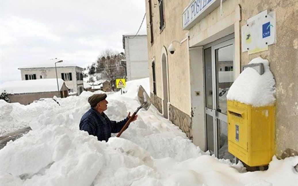 Франція, Морозалья. Чоловік розчищає вхід до поштового відділення у місті Морозалья після рясних снігопадів. Тисячі будинків залишилися без електрики, снігопади спричинили серйозні проблеми із транспортом. / © AFP