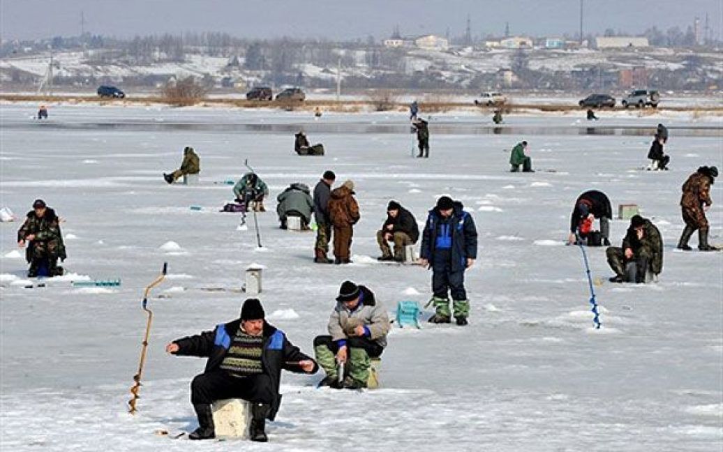 Білорусь, Лапоровічі. Рибалки сидять на льоду Мінського моря, штучного водосховища поблизу Мінська. / © AFP