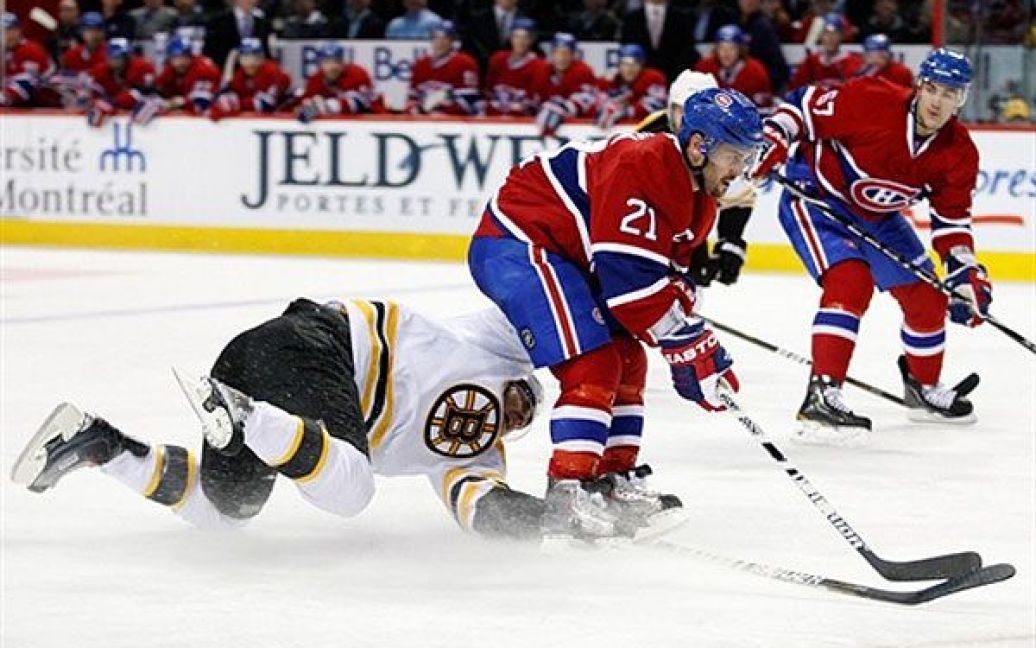 Канада, Монреаль. Гравець "Montreal Canadiens" Брайан Джіонта намагається відібрати шайбу у гравця "Boston Bruins" Джонні Бойчука під час гри НХЛ у центрі Белл в Монреалі. / © AFP
