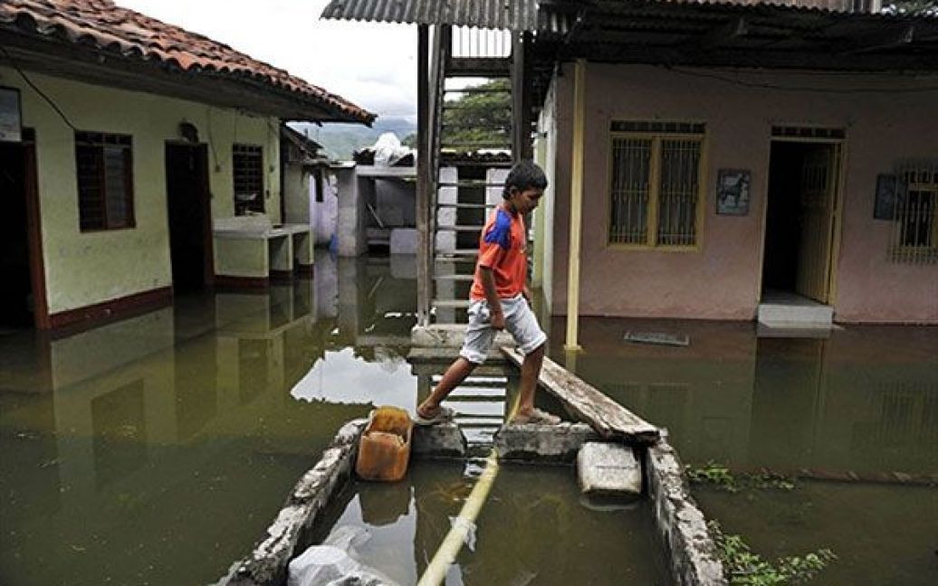 Колумбія, Бугу. Хлопчик йде повз затоплені будинки у Ель-Порвенір, сільському районі Бугу в Колумбії. Річка Каука вийшла з берегів через сильні дощі. Цього року через проливні дощі і повені у Колумбії загинули більше 100 людей, більше мільйона осіб постраждали. / © AFP