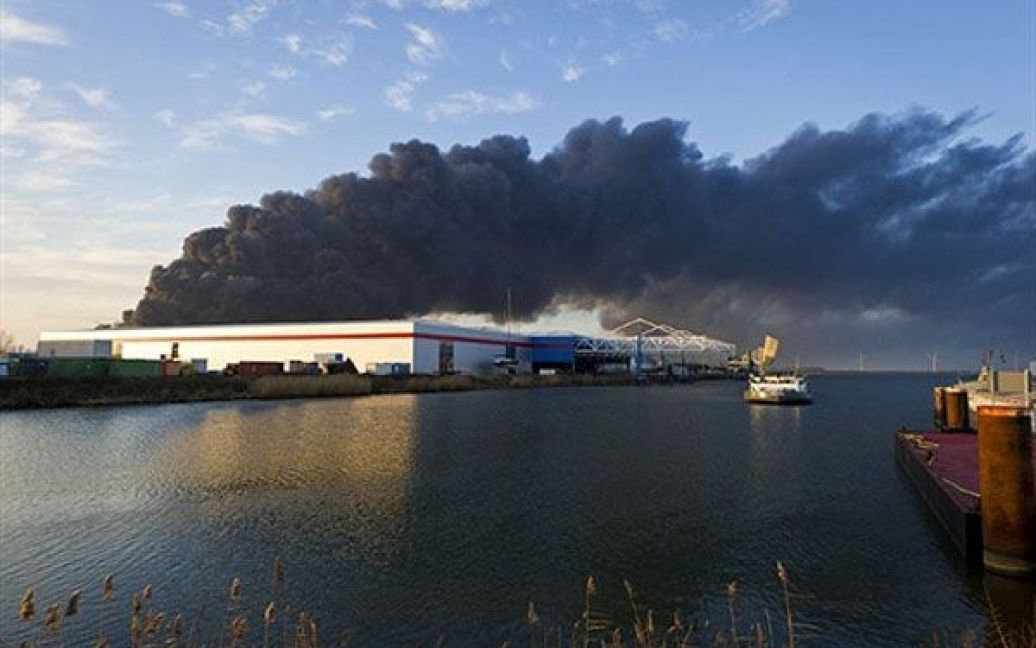 Нідерланди. Величезна хмара чорного диму здіймається над хімічним заводом "Chemie-Pack", на якому виникла пожежа, поблизу Роттердама. Доки немає інформації про жертви, але місцевим мешканцям вже порадили тримати вікна і двері закритими. / © AFP