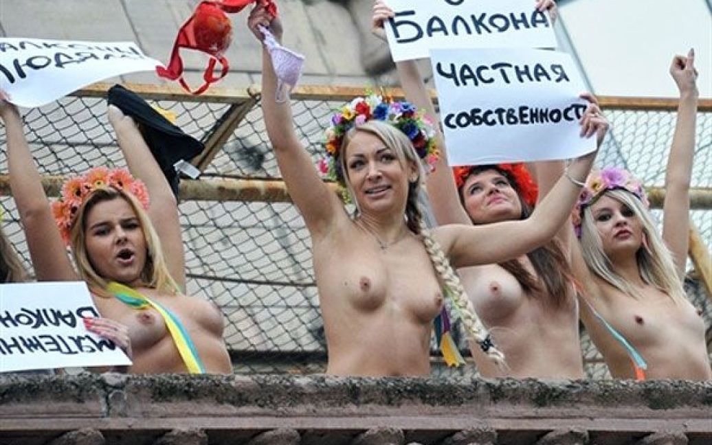 Україна, Київ. Активістки жіночого руху FEMEN провели акцію топлес-протесту під гаслами "Балкон це приватна власність" і "Існує бунтівний балкон" на балконі в центрі Києва, навпроти будівлі КМДА. Ця акція стала відповіддю на вимогу КМДА до жителів центральних районів, напередодні і під час проведення Євро-2012 зберегти свої балкони порожніми і не з&#039;являтися на балконах голими та напівголими. / © AFP