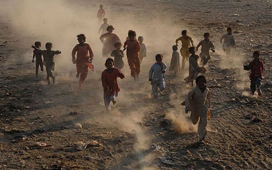 Пакистан, Лахор. Пакистанські діти грають у місті Лахор. Дощі небувалої сили викликали у країні катастрофічні повені у липні і серпні, в результаті яких було спустошено площу розміром приблизно з Англію, більше 21 млн. людей постраждали від стихійного лиха, що спіткало країну. / © AFP