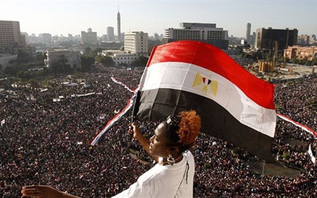 Єгипет, Каїр. Жінка розмахує єгипетським прапором на площі Тахрір у центрі Каїра, де сотні тисяч єгиптян зібралися, щоб відзначити свято завершення загальнонаціонального повстання. / © AFP