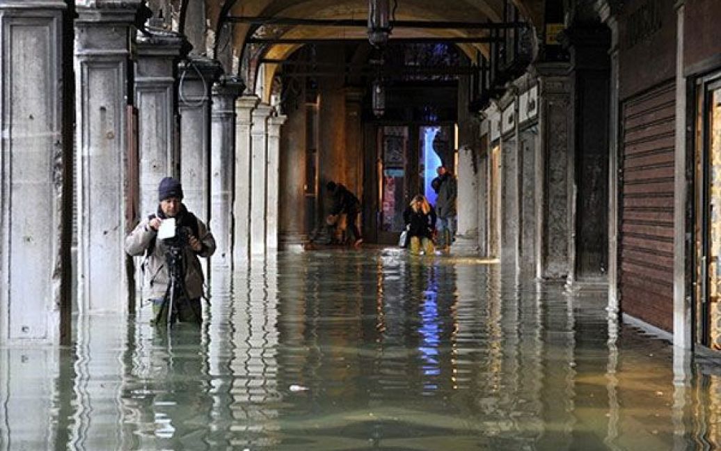 Італія, Венеція. Люди йдуть затопленою площею Сан-Марко у Венеції. Туристи у Венеції вранці прокинулися від попереджувальної сирени, оскільки "Acqua Alta" (висока вода) досягла критично високого рівня. В результаті затоплення 55 відсотків міста опинилось під водою. / © AFP