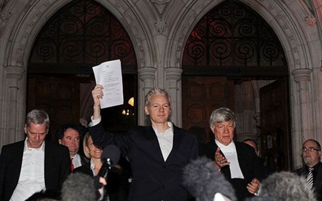Великобританія, Лондон. Засновник Wikileaks Джуліан Ассанж тримає в руці юридичні папери під час звернення до ЗМІ за межами Вищого суду в центрі Лондона. Ассанжа випустили під заставу після того, як суд відхилив апеляцію щодо його звільнення. / © AFP