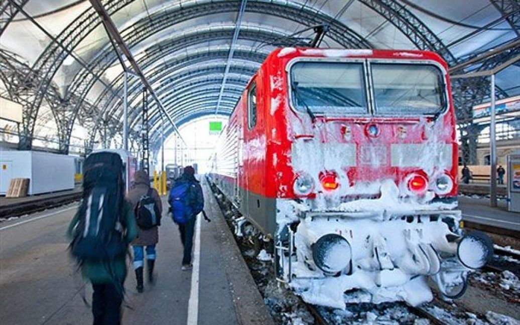 Німеччина, Дрезден. Пасажири йдуть повз вкритий льодом локомотив німецької залізниці Deutsche Bahn на вокзалі у Дрездені. У Німеччині завершується різдвяний сезон хаосу на залізниці, коли більшість рейсів була скасована через негоду. / © AFP