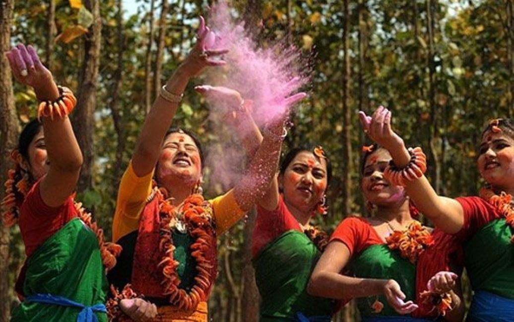 Індія, Сілігурі. Індійські художники розкидують у повітря кольоровий порошок під час репетиції майбутнього фестивалю весни. / © AFP
