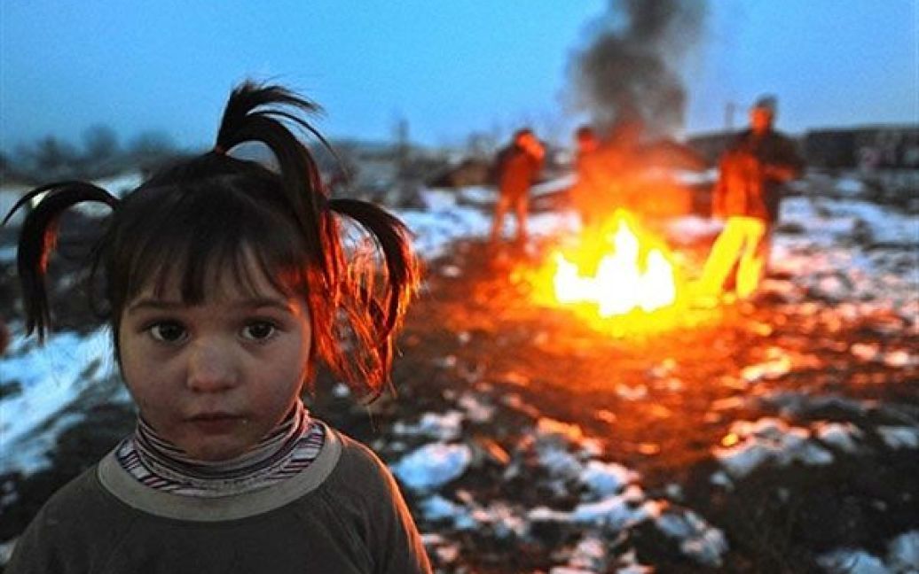 Македонія, Скоп&#039;є. Дівчинка стоїть поруч із вогнищем, біля якого гріються люди на вулиці міста Скоп&#039;є. Македонія потерпає від холодної погоди. / © AFP