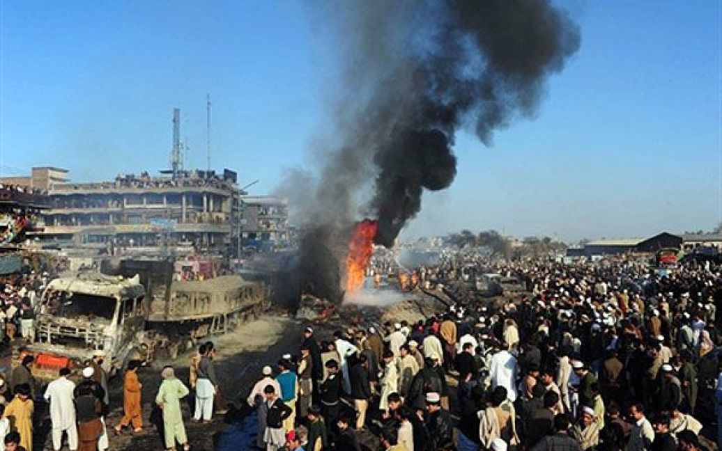 Пакистан, Пешавар. Місцеві жителі дивляться на палаючий нафтову цистерну НАТО після вибуху в Пешаварі. В результаті вибухів загинули троє співробітників служби безпеки. / © AFP