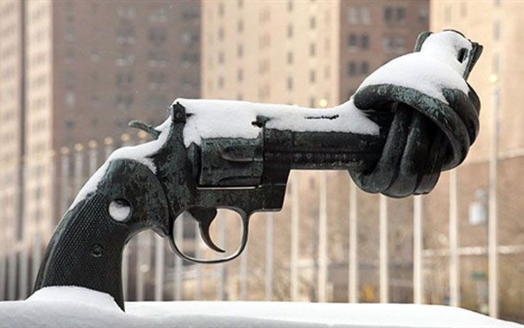 США, Нью-Йорк. Скульптура пістолета, вкрита снігом, перед будівлею Організації Об&#039;єднаних Націй у Нью-Йорку. Північний схід США потерпає від другої потужної снігової бурі. / © AFP