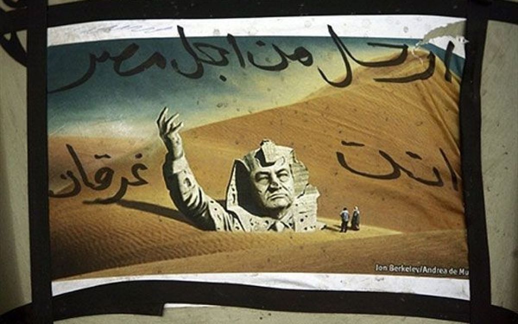 Ліван, Бейрут. Фотографія із портретом єгипетського президента Хосні Мубарака у вигляді фараона, що потопає у хитких пісках, із написом "Залиш Єгипет, ти потопаєш&rdquo; висить на будинку. У Бейруті провели акції на підтримку масових протестів по всьому Єгипту. / © AFP