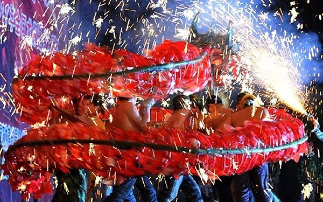 Китай. Китайці виконують танець вогняного дракона під час святкувань на честь першого повного місяця цього місячного Нового року. / © AFP